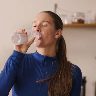 MaxiNutrition Hydration Tabs – Frau trinkt Elektrolyt-Drink aus der Flasche